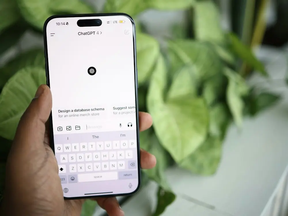 A hand holding a phone with an AI chat app open