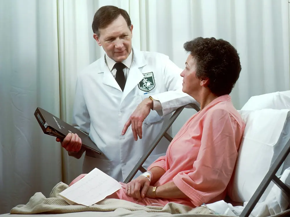 A doctor talking with a patient in a hospital bed