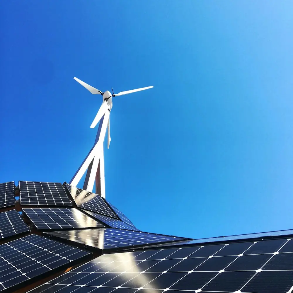 Small wind turbine standing beside rooftop solar panels